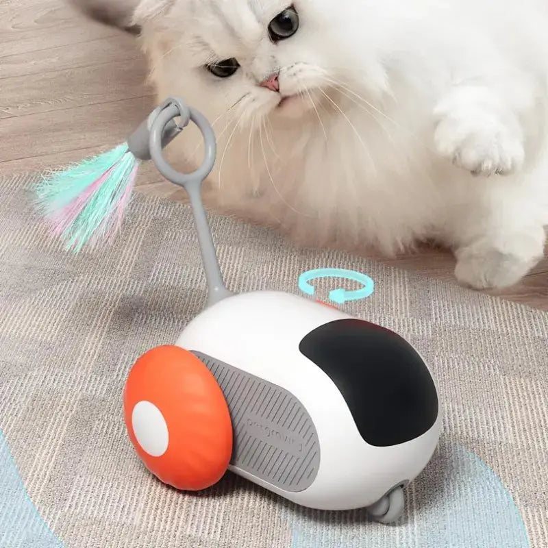 White robotic interactive cat car toy with orange wheel and feather attachment.