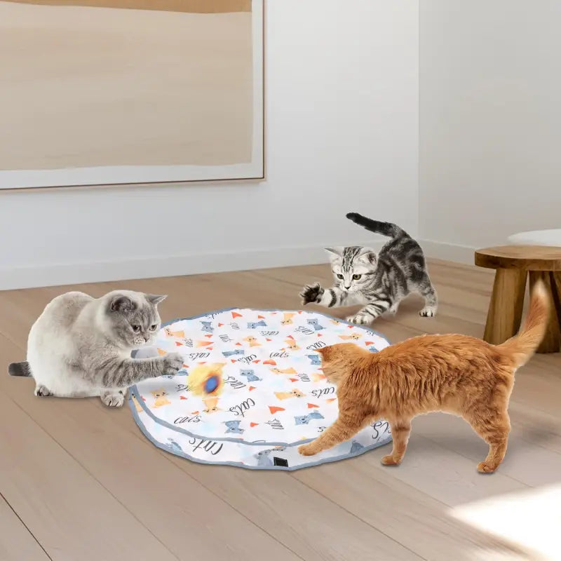 Round cat play mat with three cats enjoying the Motion Activated Interactive Cat Toy Ball